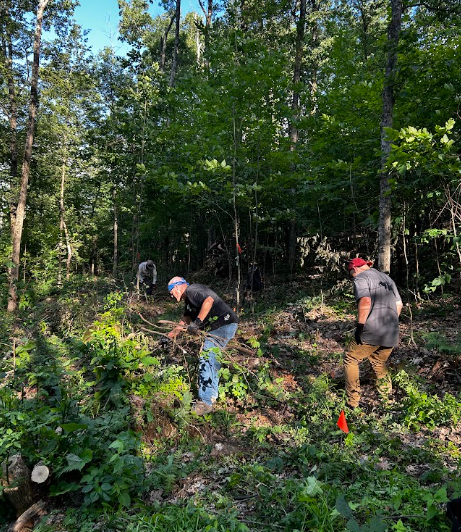 Two volunteers clearing mountain bike trails of debris.